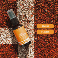 CBD Oral Spray bottle with orange label on a textured surface