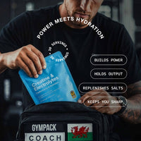 Person holding a creatine and electrolytes supplement packet with text about its benefits.