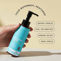 Hand holding a blue bottle labeled 'fourfive' with text about product benefits on a beige background